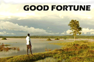 Image of Kenyan man walking across a flooded field.
